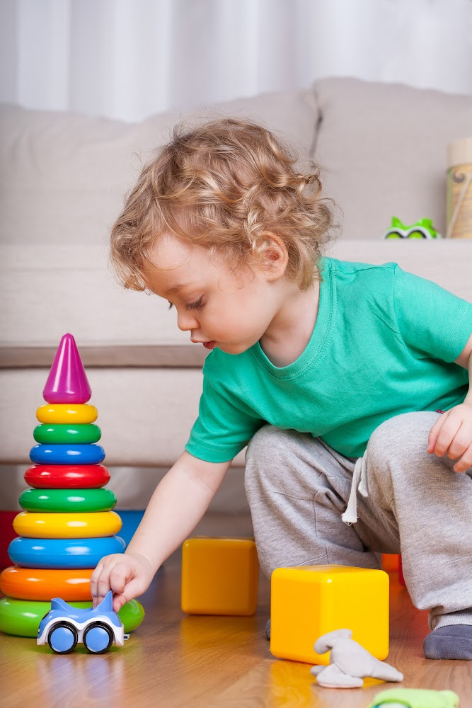 Toddler playing with toys and a car
